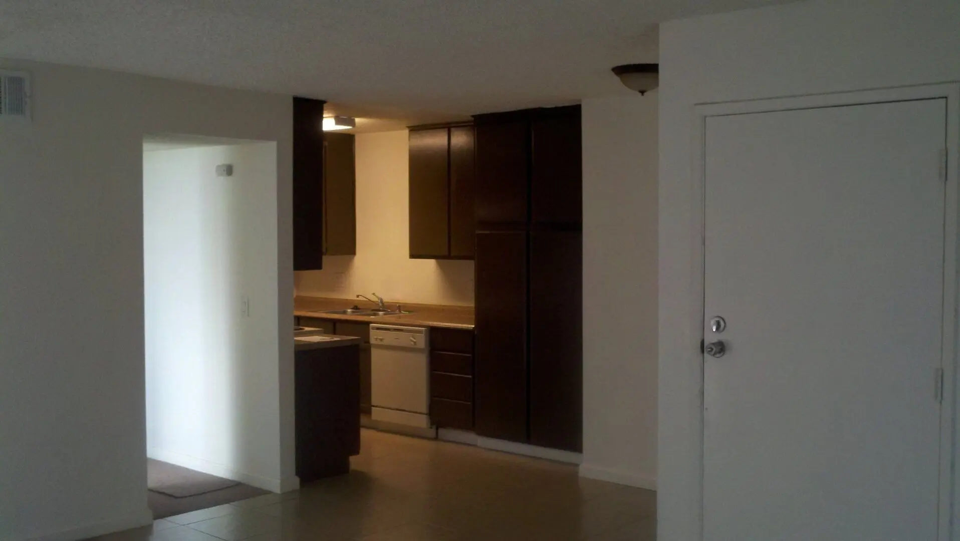 A modern kitchen with dark cabinets and stainless steel appliances.