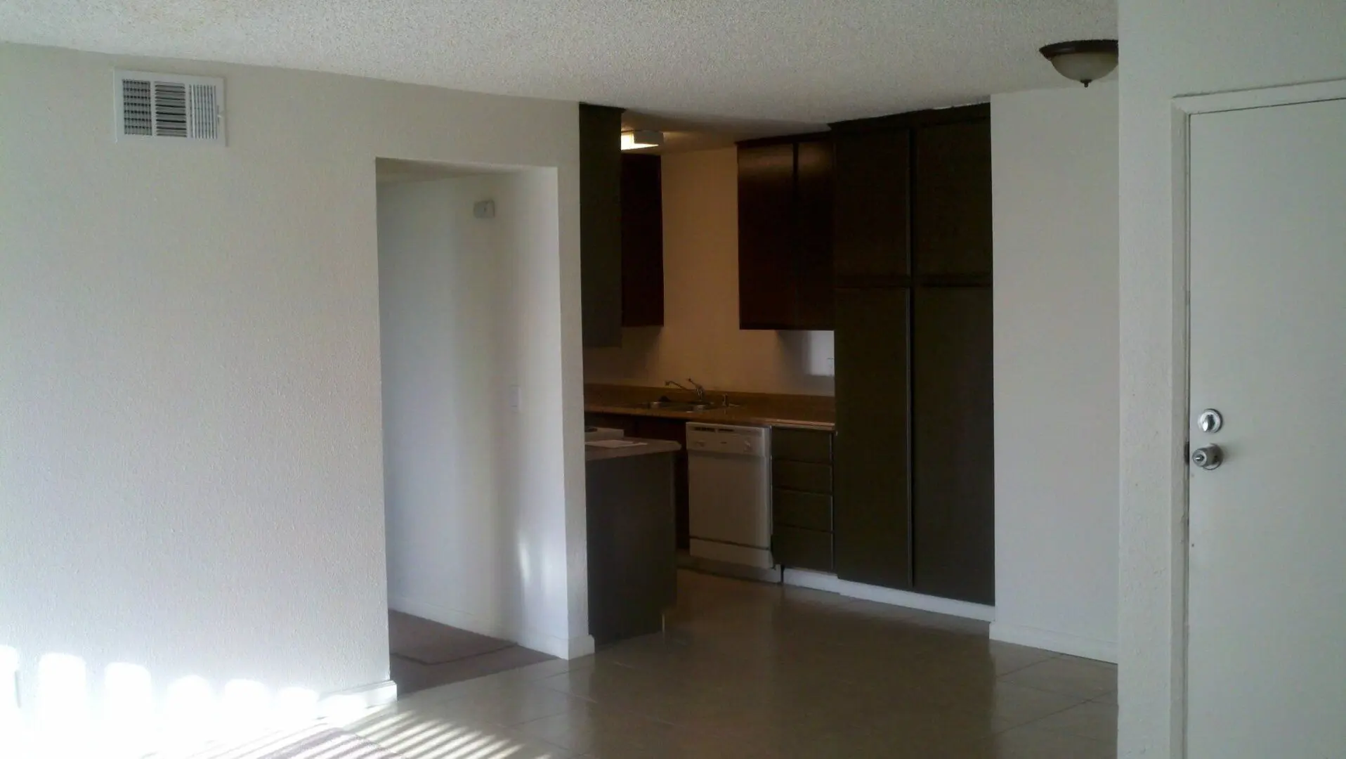 Modern kitchen with dark cabinets and light walls.