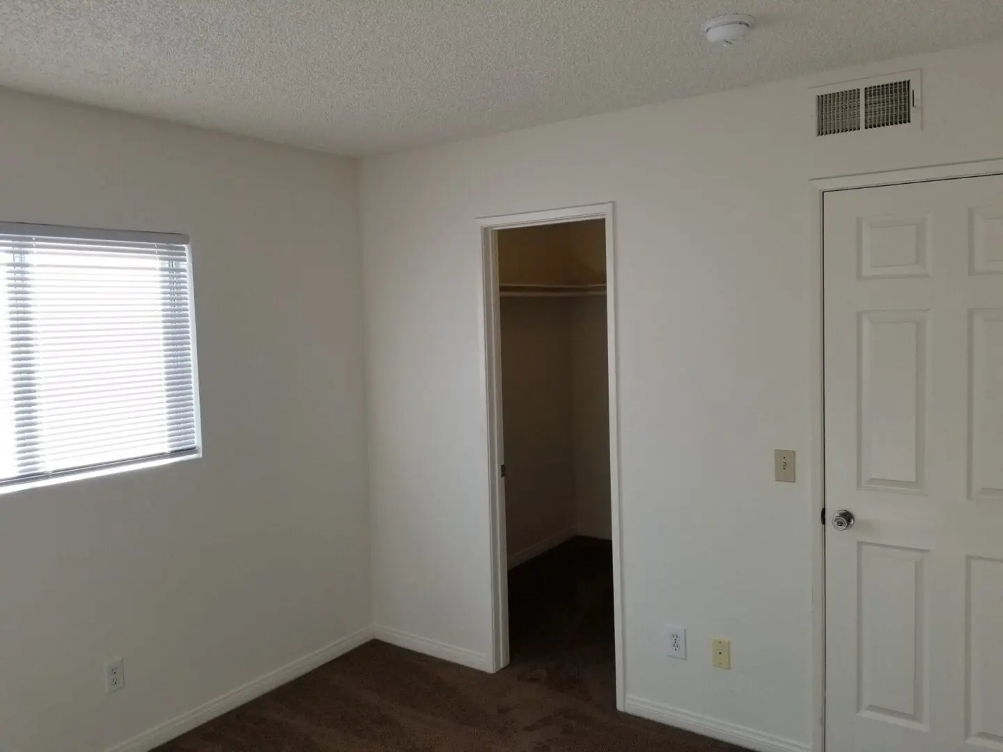 Empty room with a window and open closet door.