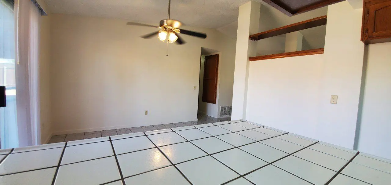 Empty living area with tiled kitchen counter