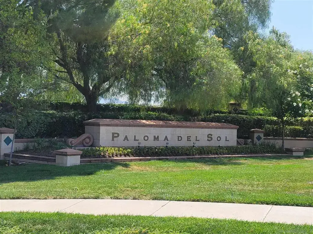 Entrance sign for Paloma Del Sol community surrounded by greenery.