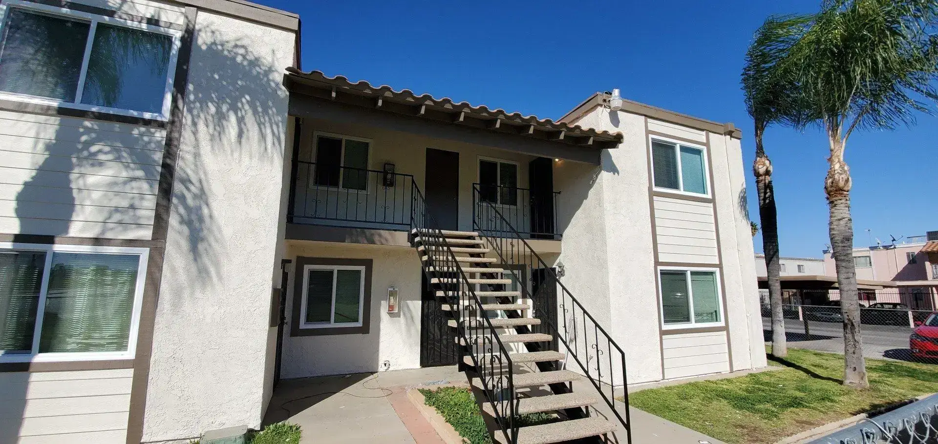 Two-story apartment building with external staircase and balconies.