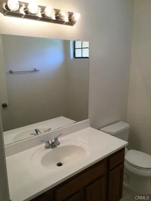 Simple bathroom with sink, mirror, and toilet.