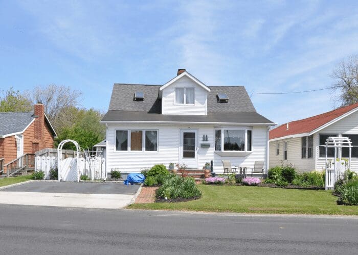White house with garden and driveway.