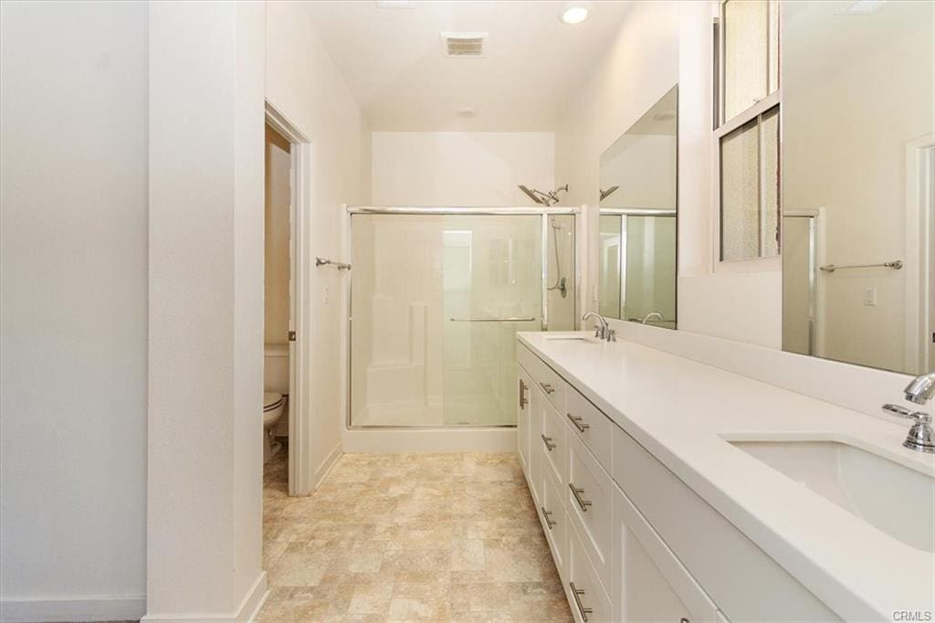Modern bathroom with large mirror and shower.