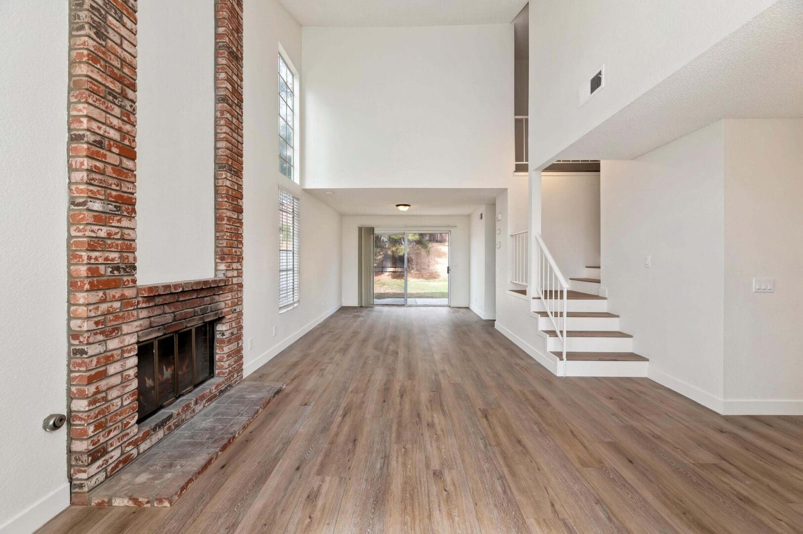 Spacious living room with brick fireplace.