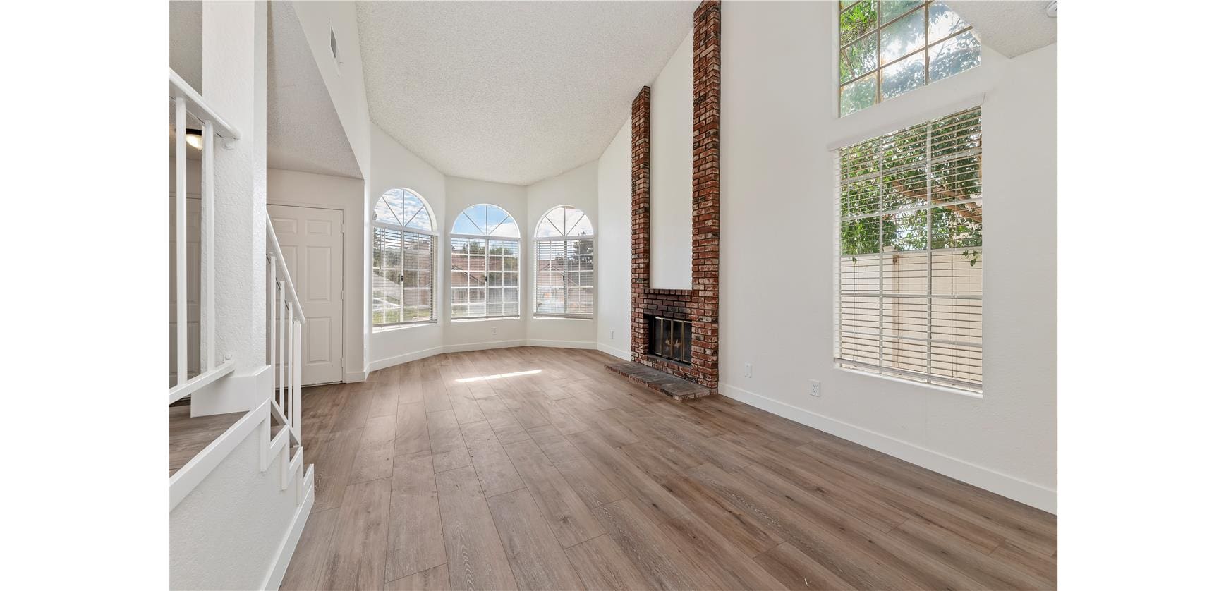Bright living room with large windows and fireplace.