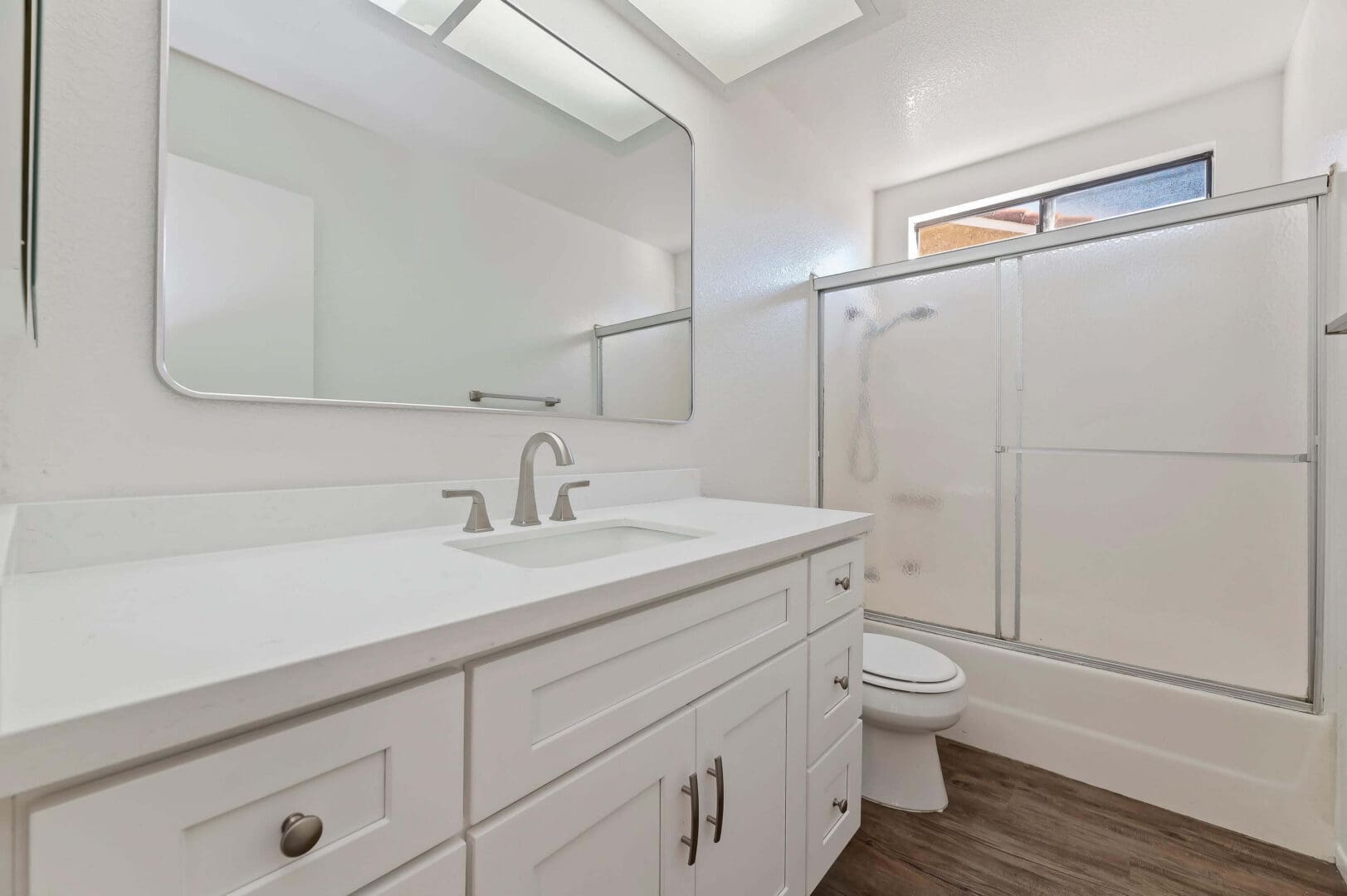 Modern white bathroom with large mirror.