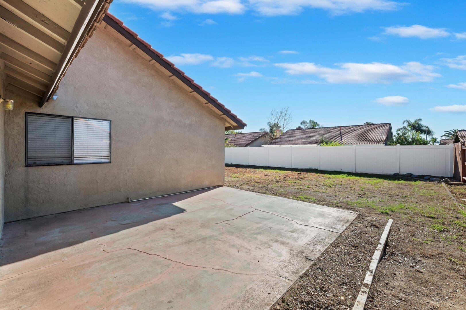 Backyard with concrete patio and lawn.